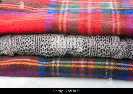 Stack of cosy winter wool blankets in tartan red, blue, grey colors, selective focus Stock Photo