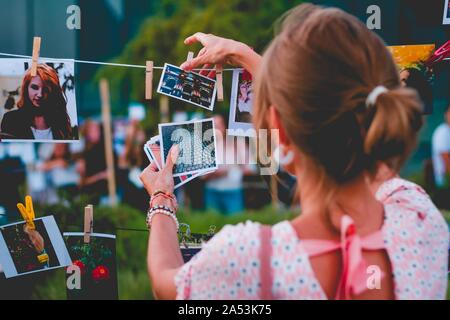 Family photos hanging over spring flowersThe girl hangs photos on a rope. Photo exhibition. Stock Photo