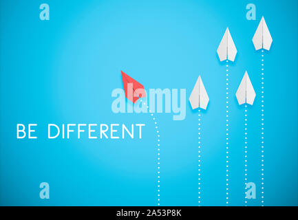 be different concept. red paper airplane is flying in different direction from white paper airplanes Stock Photo