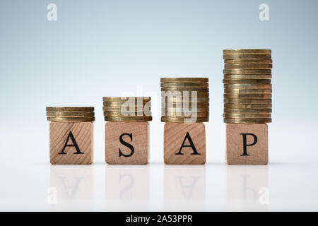 Coins Stacked On Asap Letters. Time Is Money Concept Stock Photo