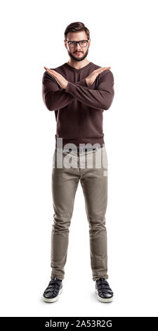 A bearded man in fashionable casual clothes stands with hands making a cross in front of him. Stock Photo