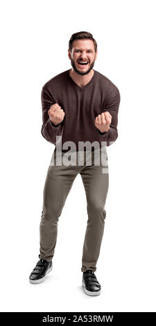 An aggressive bearded man in casual clothes shouts at camera, shows his teeth and holds fingers in tight fists. Stock Photo