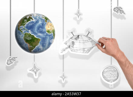 Earth with man's hand holding a picture of big UFO on the white background Stock Photo
