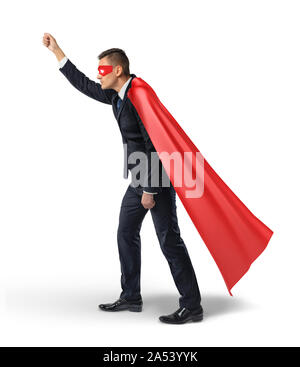 A businessman in a hero red cape and an eye mask standing in side view and holding an invisible signboard. Stock Photo