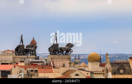 Madrid, Spain - June 4, 2017: City rooftops and neoclassical quadriga Roman Chariot statues on Banco Bilbao Vizcaya BBVA bank building built in 1923 Stock Photo