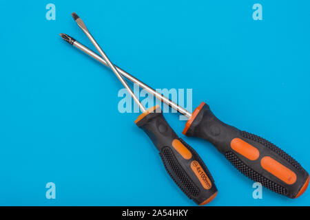Home improvement: two screwdrivers (philips and slotted) on a blue flat lay background with copy space. Stock Photo