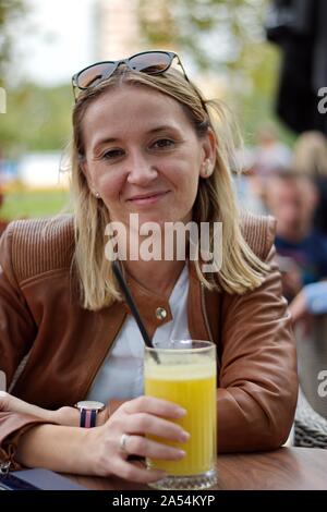 Portrait of the mature woman sitting in the restaurant drinking juice Stock Photo