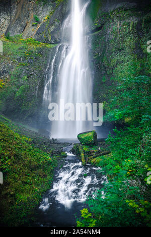 Smooth water on cliff bottom with bright green moss Stock Photo