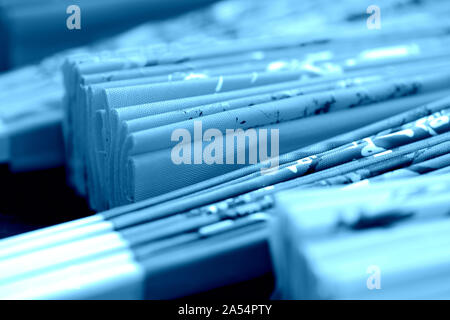 Folded Vietnamese fans on a dark background close-up. Blue color toned Stock Photo