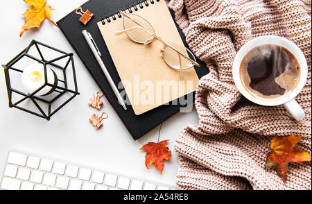 Autumn composition. Cup of coffee, women fashion sweater, dried leaves,  notebooks. Autumn, fall concept. Flat lay, top view, copy space Stock Photo