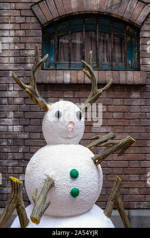 cute plastic snowman display in front of brick wall Stock Photo