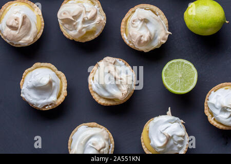 Lemon meringue tarts on black background - top view photo of limes and lime meringues Stock Photo