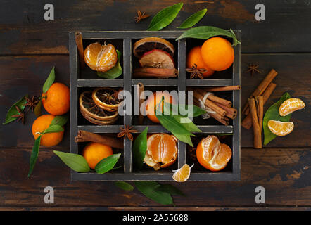 Mandarins  and spices in a box on a dark wooden background Stock Photo