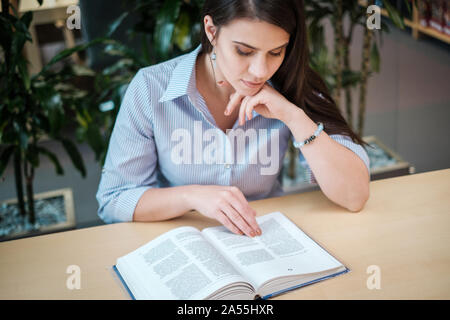 Multicultural group of students studying in a public library. Stock Photo