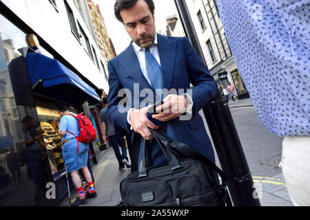 London, England, UK. Businessman using his mobile phone in the street Stock Photo