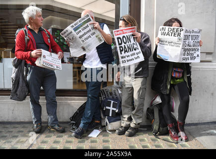 Protesters read mock-up newspapers in Oxford Circus, London, during an Extinction Rebellion (XR) climate change protest. Stock Photo