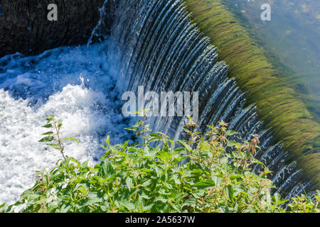 Silt-laden water rushing over a weir on the River Stour Blandford Dorset  England UK Stock Photo - Alamy