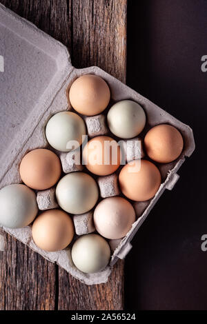 Overhead view of a dozen free range eggs in a carton on wooden surface Stock Photo