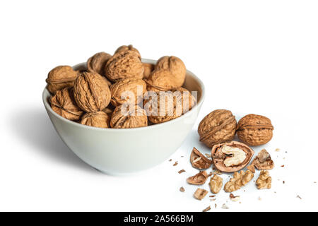 White bowl full of walnuts with open walnut on a white background Stock Photo