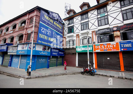 Srinagar, India. 18th Oct, 2019. A woman walks past closed shops during shutdown in Srinagar.Kashmir valley continued to remain shut on the 75th consecutive day against the abrogation of Article 370 by central government which grants special status to Jammu & Kashmir. Credit: SOPA Images Limited/Alamy Live News Stock Photo