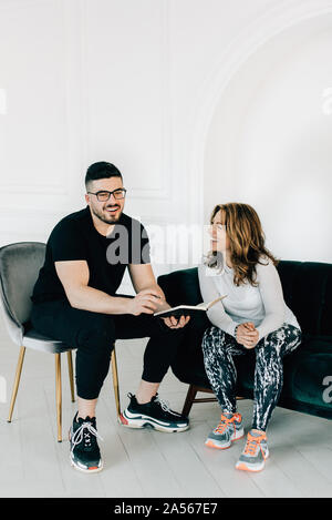 Fitness instructor talking to woman in studio Stock Photo