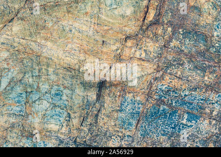 Close up macro view of cracked stone surface brown, gray and blue color. Detailed nature pattern texture or background taken in natural environment Stock Photo