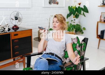 Businesswoman using cellular phone in office Stock Photo