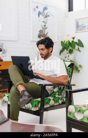 Businessman using laptop in office Stock Photo