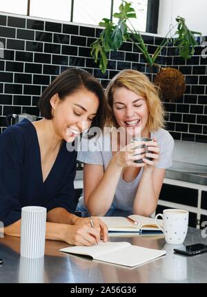 Colleagues talking and working at coffee break in pantry Stock Photo