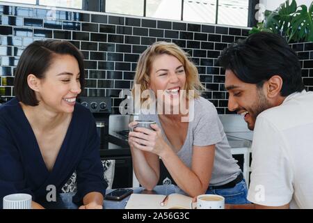 Colleagues talking and working at coffee break in pantry Stock Photo