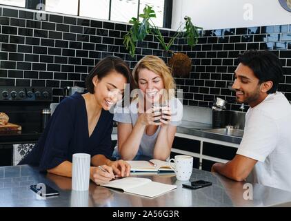 Colleagues talking and working at coffee break in pantry Stock Photo