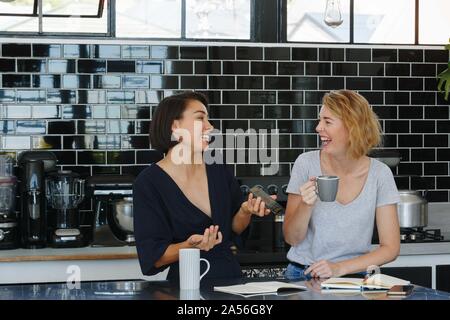 Colleagues talking and working at coffee break in pantry Stock Photo