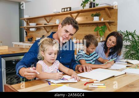 Parents helping children with homework at home Stock Photo