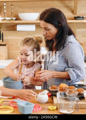 Family women baking cupcakes in kitchen grandmother, mother and ...