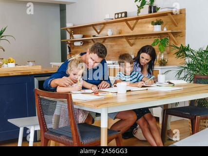 Parents helping children with homework at home Stock Photo