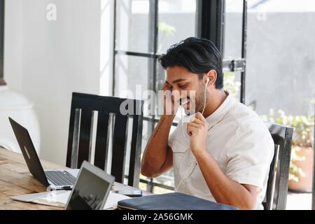 Businessman talking on cellular phone in office Stock Photo