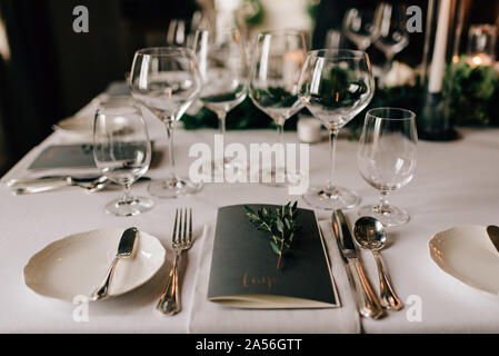 Place setting at wedding reception table with cutlery, menu and drinking glasses Stock Photo