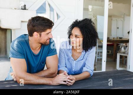 Loving couple staring at each other in beach house Stock Photo