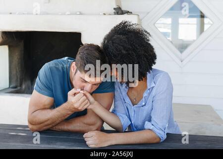 Man kissing woman's hand in beach house Stock Photo
