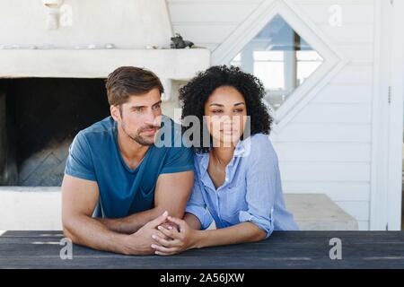 Couple in deep thought in beach house Stock Photo