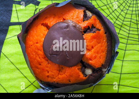 Orange and chocolate muffin cake on Halloween serviette napkin - looking down on from above Stock Photo