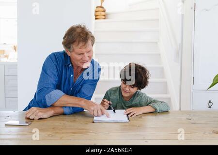 Father helping son with homework at home Stock Photo
