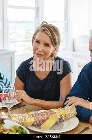 Woman listening attentively at dining table in home party