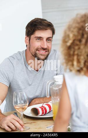 Father listening attentively to daughter at dining table Stock Photo