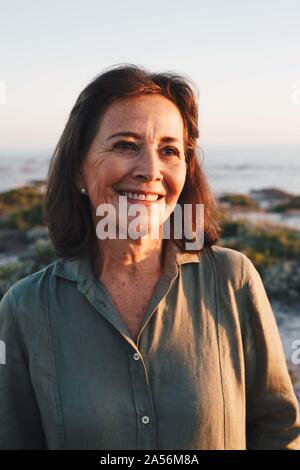 Senior woman enjoying sun on beach Stock Photo