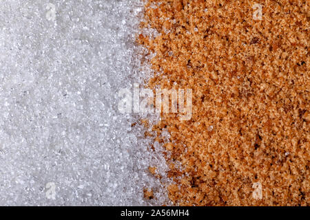 A lot of refined white sugar next to another pile of unrefined brown cane sugar. Stock Photo