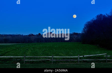Super Moon Rising Over Field with Fence. Stock Photo