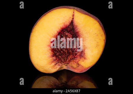 One half of sweet red peach isolated on black glass Stock Photo