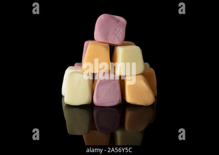 Lot of whole soft pastel candy isolated on black glass Stock Photo