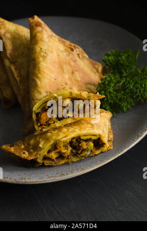 Samosas a spicy blend of vegetables or meat wrapped in a deep fried triangular pastry parcel a popular snack in the Middle East and South Asia Stock Photo